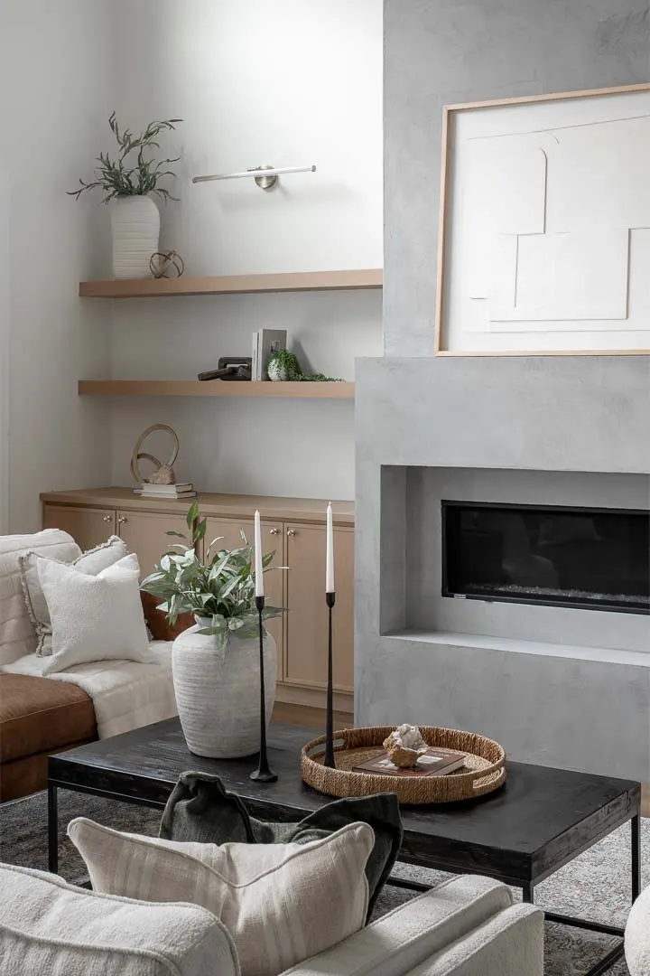 Living room with built-in shelves and a plaster fireplace